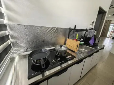 a kitchen counter with two pots and pans on a stove at Suite Karangan Near Inokom in Titi Karangan