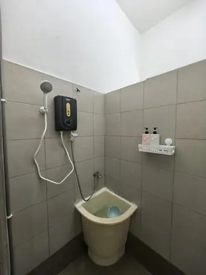 a bathroom with a toilet with a phone on the wall at Suite Karangan Near Inokom in Titi Karangan
