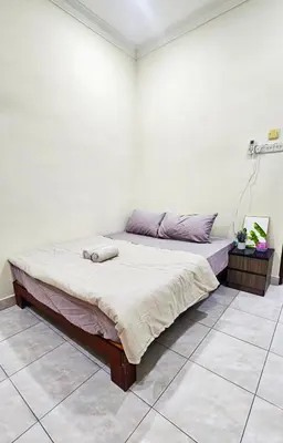a bed in a room with a white wall at Venice Manjung, Lumut by TZ Homestay in Lumut