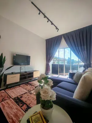 a living room with a blue couch and a tv at ZE VI Homestay,Tanah Rata in Tanah Rata