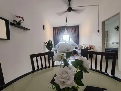a dining room table with a vase of flowers on it at ZE VI Homestay,Tanah Rata in Tanah Rata