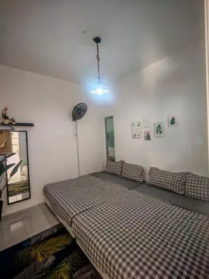 a bedroom with a bed with a checkered blanket at ZE VI Homestay,Tanah Rata in Tanah Rata