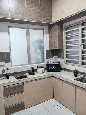 a kitchen with white counter tops and wooden cabinets at ZE VI Homestay,Tanah Rata in Tanah Rata