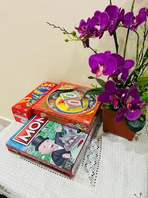 two magazines on a table next to a vase with purple flowers at Utaqha Ventures Homestay in Seri Manjung