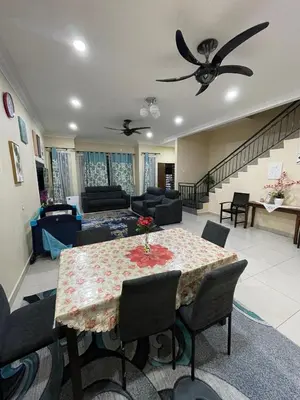 a living room with a dining table and a couch at Utaqha Ventures Homestay in Seri Manjung