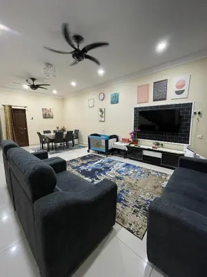 a living room with two couches and a tv at Utaqha Ventures Homestay in Seri Manjung
