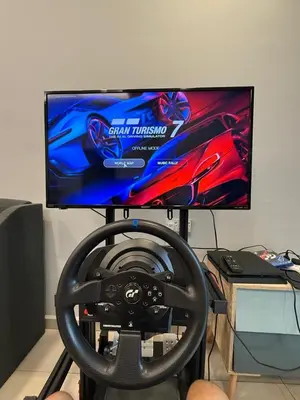 a computer monitor sitting on a stand with a steering wheel at AYAAN GAMING HOME at Quintet Play Free GranTurismo in Tanah Rata