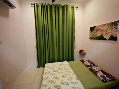a bedroom with a green curtain and a bed at Arrisa Guest House d'Anderson Ipoh Perak in Kampong Kepayang