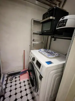 a washing machine with a microwave on top of it at Arrisa Guest House d'Anderson Ipoh Perak in Kampong Kepayang