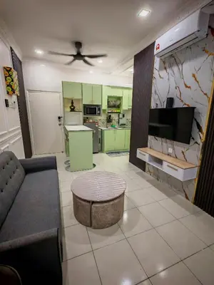 a living room with a couch and a tv at Arrisa Guest House d'Anderson Ipoh Perak in Kampong Kepayang