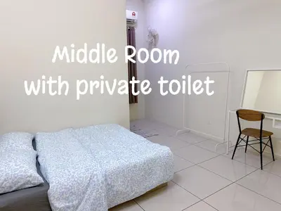 a bedroom with a bed and a table and a chair at 365 Homestay in Kampong Lima Kongsi