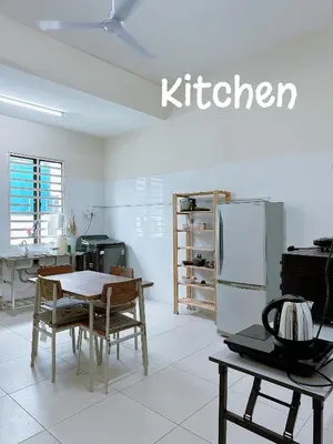 a kitchen with a table and a refrigerator at 365 Homestay in Kampong Lima Kongsi