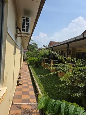a walkway in front of a building with plants at Permata Atiey Homestay in Seri Iskandar