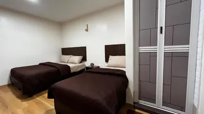 two beds in a small room with two beds at Skye Apartment Hotel in Brinchang