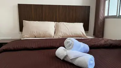a bed with two towels laying on it at Skye Apartment Hotel in Brinchang