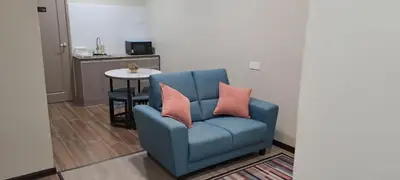 a blue chair with two pillows on it in a living room at Skye Apartment Hotel in Brinchang