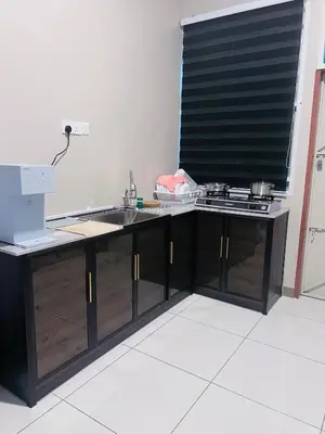 a kitchen counter with a sink and a stove at Lunas Indah Homestay in Lunas