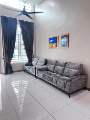 a living room with a sectional couch and a window at Lunas Indah Homestay in Lunas