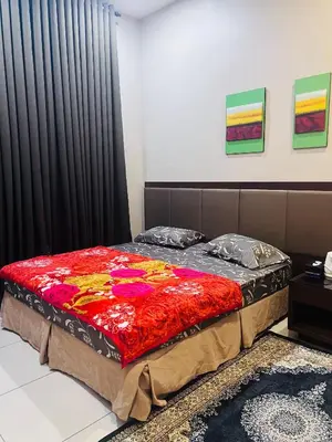 a bed with a colorful blanket on it in a room at Lunas Indah Homestay in Lunas