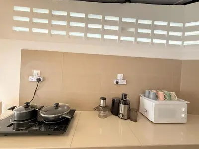 a kitchen with two pots and pans on a stove at TwinTree Kelawai in George Town