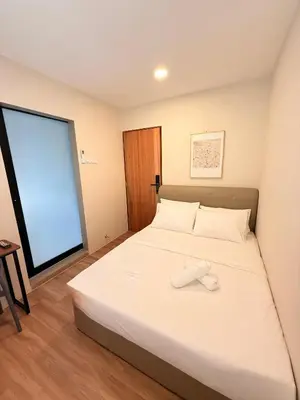 a bedroom with a large white bed with a window at TwinTree Kelawai in George Town