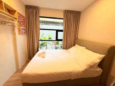 a small bedroom with a bed with a window at TwinTree Kelawai in George Town