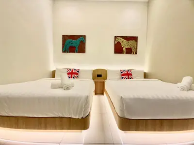 two beds in a room with paintings on the wall at LYL EvenHill Private Pool-18-23pax 5BR in Ipoh