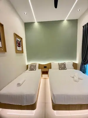 two beds in a room with a green wall at LYL EvenHill Private Pool-18-23pax 5BR in Ipoh