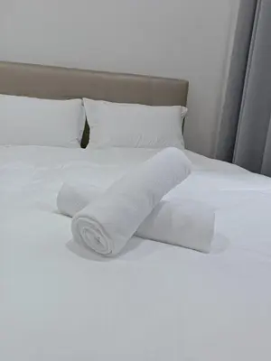 a stack of white towels on a bed at The Sun condo at taman sri nibong ,near queenbaymall in Bayan Lepas
