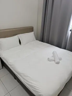 a bed with two white sheets and pillows at The Sun condo at taman sri nibong ,near queenbaymall in Bayan Lepas