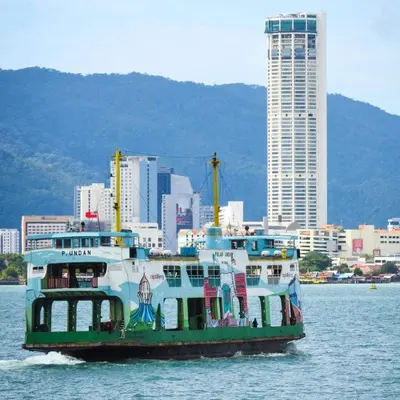 a boat in the water with a city in the background at Georgetown Homestay in George Town