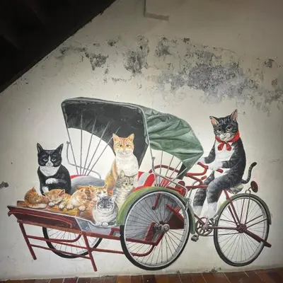 a painting of cats sitting in a carriage at Georgetown Homestay in George Town