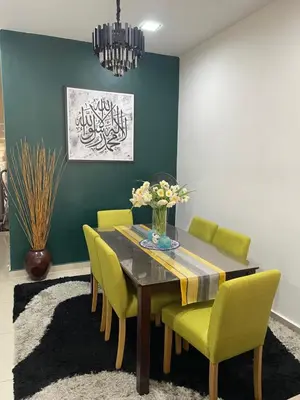 a dining room with a table and green chairs at COZY Residence Homestay Teluk Senangin Lumut in Lumut