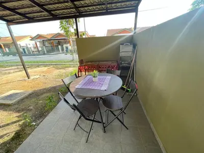 a table and chairs sitting on a patio at COZY Residence Homestay Teluk Senangin Lumut in Lumut