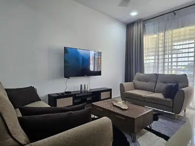 a living room with two couches and a flat screen tv at COZY Residence Homestay Teluk Senangin Lumut in Lumut