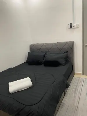 a black bed with a black blanket and two pillows at COZY Residence Homestay Teluk Senangin Lumut in Lumut