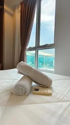 a bed with a remote control on it with a window at High-Rise Suite with view-Near Gurney & Gleneagles in George Town