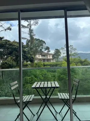 a table and two chairs in front of a window at Lily Dante in Tanah Rata