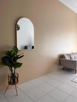 a room with a mirror and a couch and a plant at Lily Dante in Tanah Rata