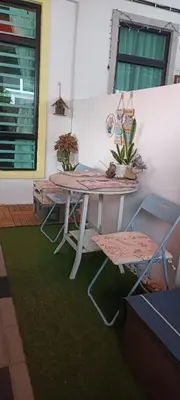a table and two chairs on a green rug at HEE & PENNIE House in Ipoh