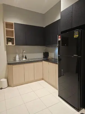 a kitchen with black cabinets and a black refrigerator at CozyHome - 3 bedroom Town House with unlimited free Wi-Fi in Sitiawan