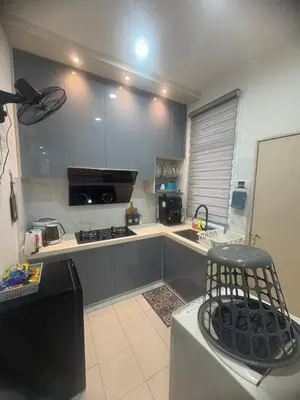 a kitchen with gray cabinets and a black refrigerator at HoMestaY Kulim Seri Rambai in Kulim
