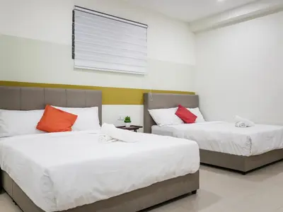 two beds in a room with white and red pillows at Wishful Guesthouse at Georgetown#LohGuanLye#BudgetStay in George Town