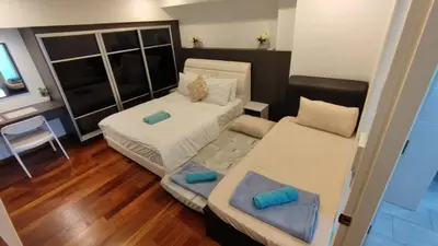 a small room with two beds and a desk at Cozy Seaview Duplex Apartment at Sunrise Gurney in George Town