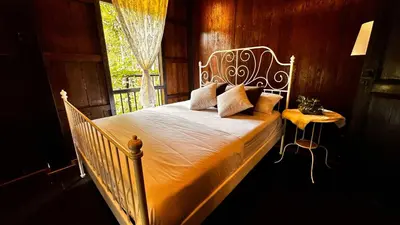 a bedroom with a white bed and a window at Charming Nature Kampung Home for Family Getaways in Benta