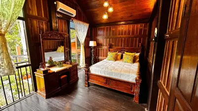 a bedroom with a bed and a large mirror at Charming Nature Kampung Home for Family Getaways in Benta