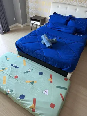 a bed with a blue comforter with letters on it at High Floor Naz Comfort Suite Champs Elysees in Kampar