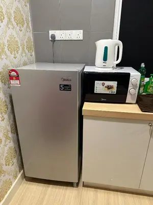 a kitchen with a refrigerator and a microwave at High Floor Naz Comfort Suite Champs Elysees in Kampar