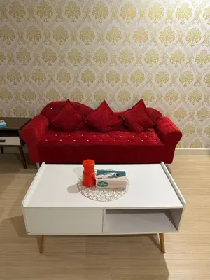 a red couch in a living room with a coffee table at High Floor Naz Comfort Suite Champs Elysees in Kampar