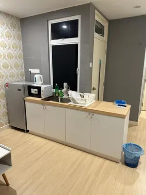 a kitchen with a counter and a sink and a refrigerator at High Floor Naz Comfort Suite Champs Elysees in Kampar